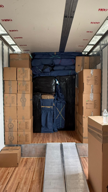 Moving truck packed tightly with boxes and padded furniture”