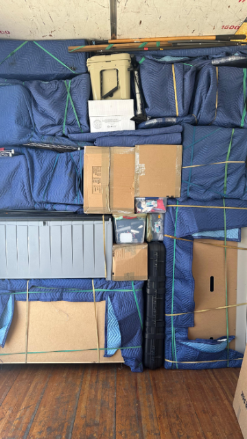 Efficiently stacked boxes and wrapped furniture inside moving truck